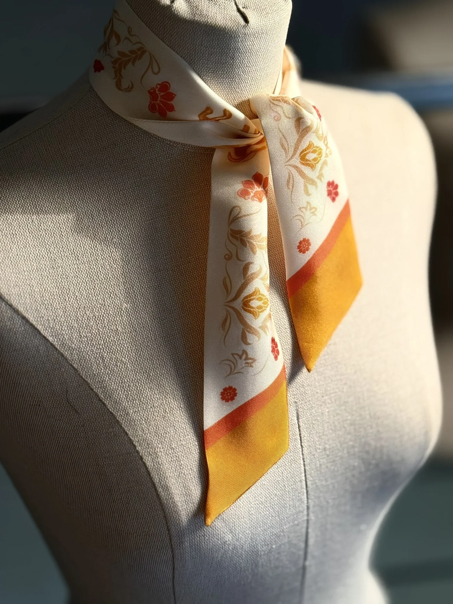 Foulard de soie imprimé noué sur un buste de couture