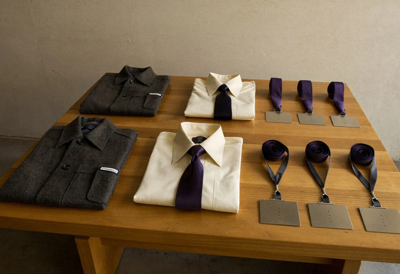 Vestes, chemises et cravates d'un vestiaire d'entreprise disposées sur une table
